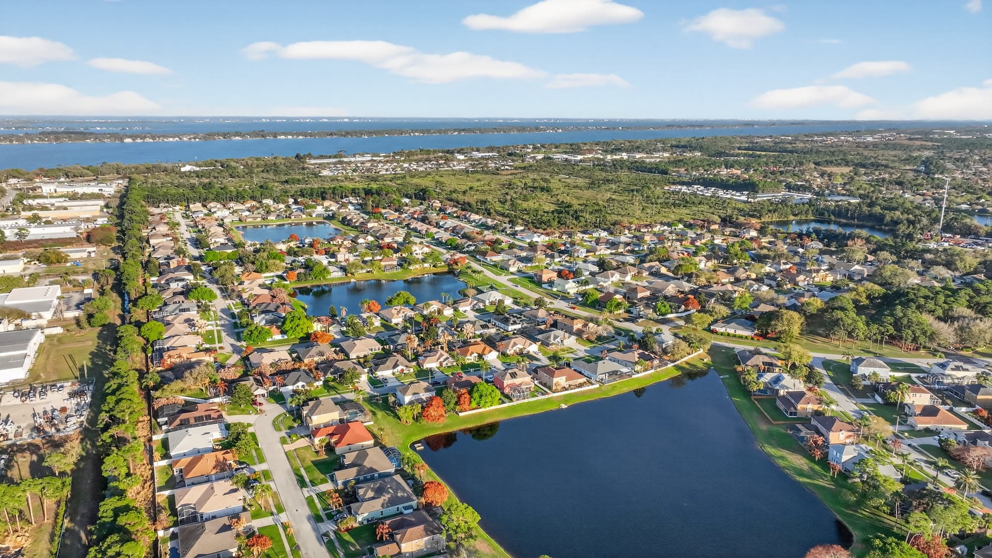 Aerial view of a Central Florida waterfront neighborhood with the Indian River Lagoon in the distance