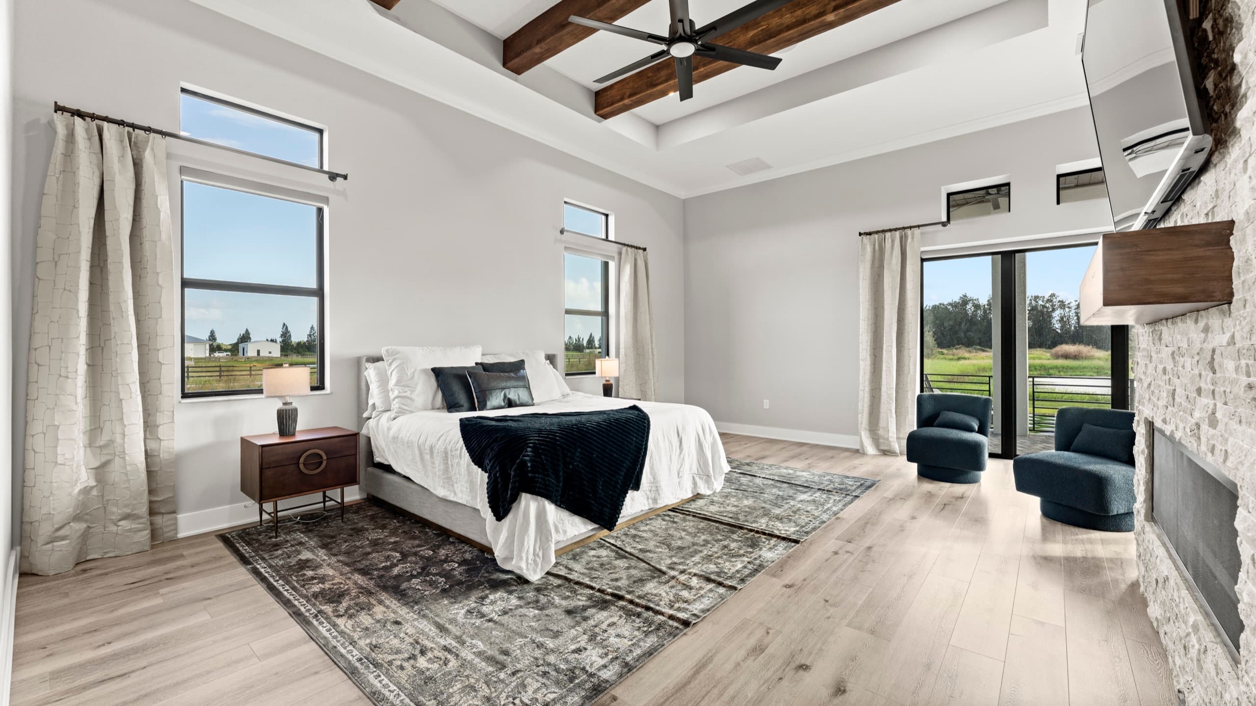 Master bedroom with morning light through wide windows